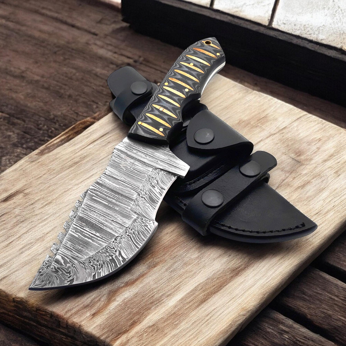Handmade Damascus knife displayed on rustic wood background

